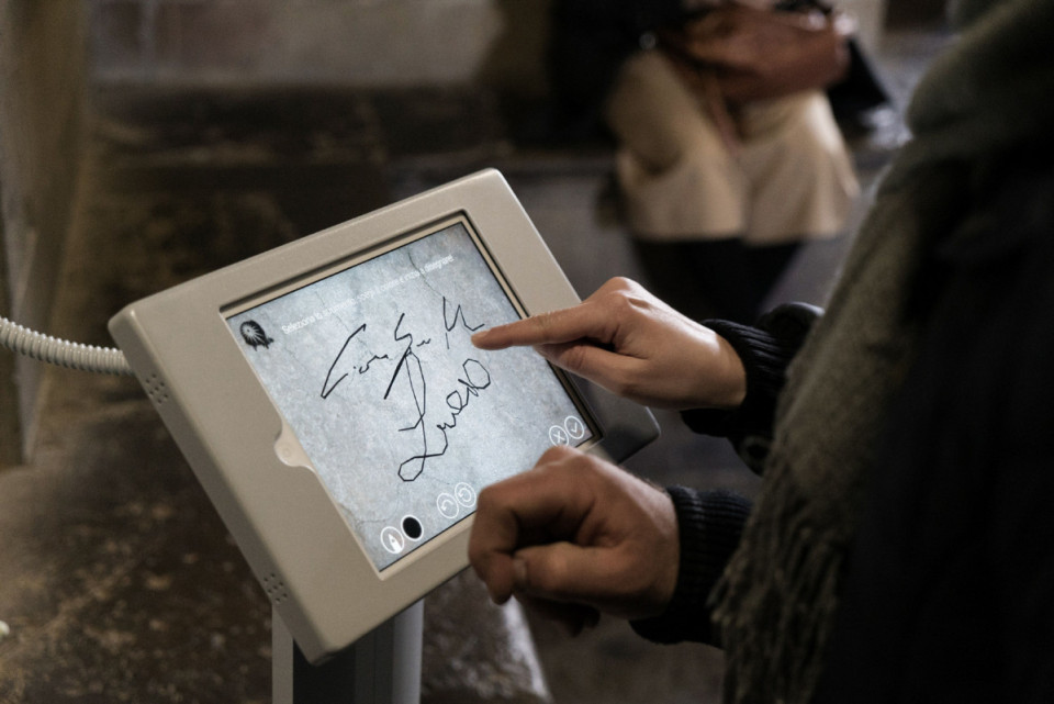 A tourist uses a computer tablet in Giotto's bell tower, which allows them to leave their mark at the site digitally, in Florence, Italy, March 14, 2016. Officials here have decided to try a virtual solution to their age-old problem of graffiti left by visitors to the historic site. (Alessandro Grassani for The New York Times)