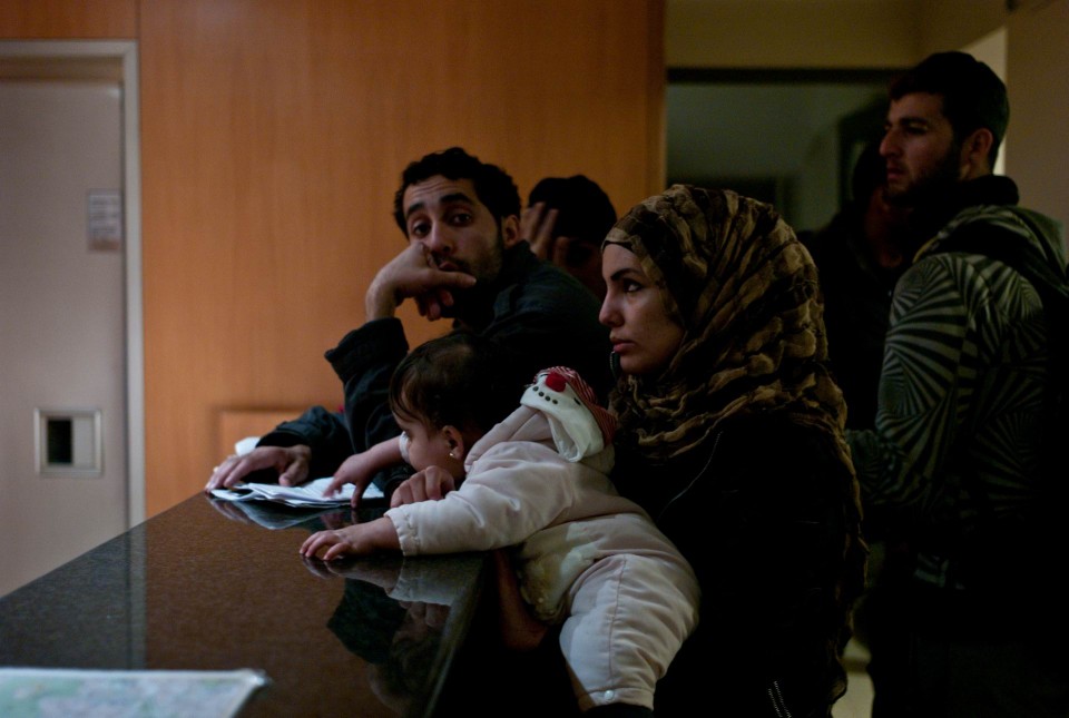 Οικογένειες προσφύγων περιμένουν σε ξενοδοχείο του κέντρου για να βρούν δωμάτιο.