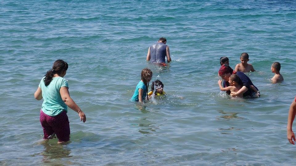 Οι πρόσφυγες προκειμένου να προστατευυτούν από τις υψηλές θερμοκρασίες μπαίνουν στη θάλασσα με τα ρούχα.