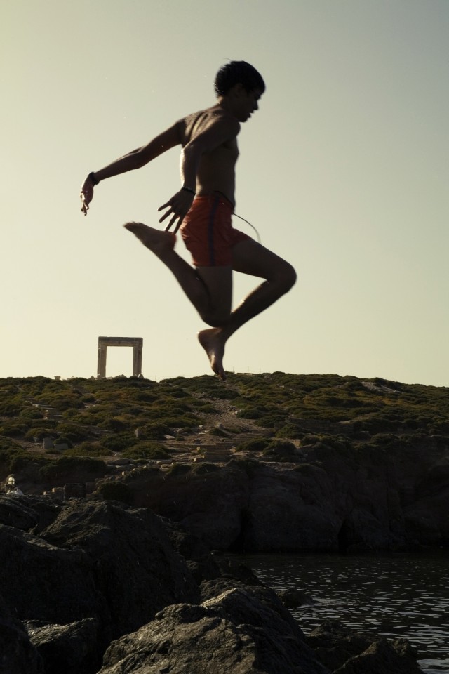 Αγόρι βουτάει στη θάλασσα με φόντο την Πορτάρα. 