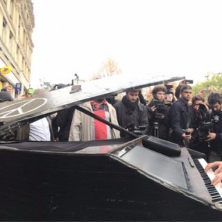 Μουσικός παίζει έξω από το θέατρο Μπατακλάν το Imagine του Τζον Λένον