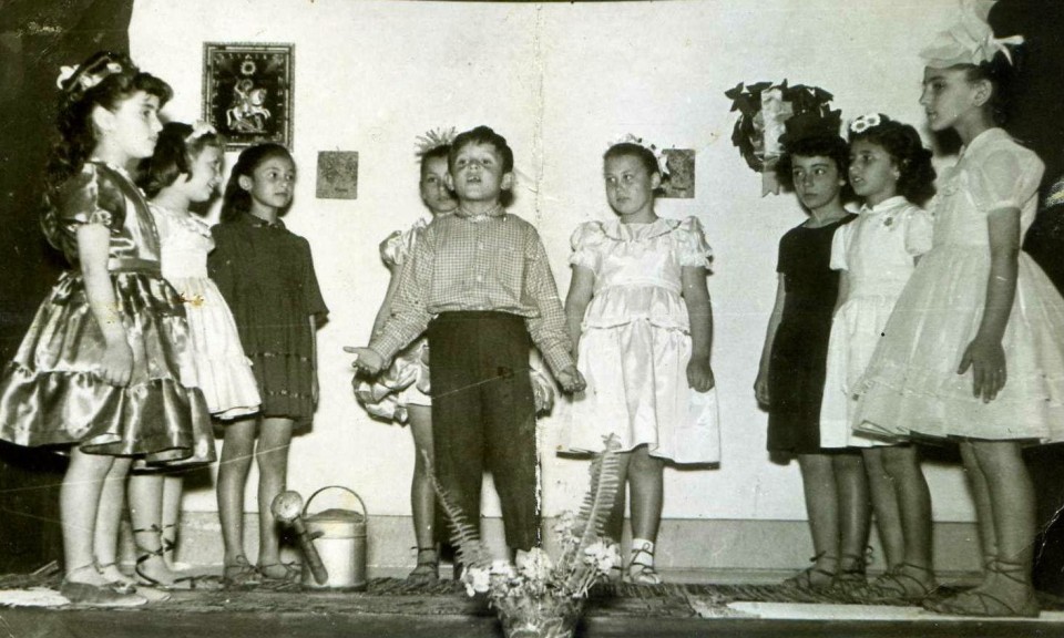 Σε αλλη μια γιορτη του  δημοτικού εδω ολα τα λουλουδια του κήπου στην μέση κηπουρός ο Νικολάκης. Εγω εξω αριστερά  κάνω τον βασιλικό. Το φουστάνι μου ειναι απο καταπράσινη σατέν φόδρα. Ολα και τα παπουτσια μου τα έραψε η μαμά μου που μου εκανε και το περίτεχνο "αρχαιοελληνικό" χτένισμα στολισμένο με "ανθάκια" βασιλικού. Η φιληναδα μου η Ευθυμούλα δεξιά στην φωτογραφία που κανει το Ρόδο πηγε στο κομμωτήριο και ζητησε το ιδιο χτένισμα με μένα! <3  