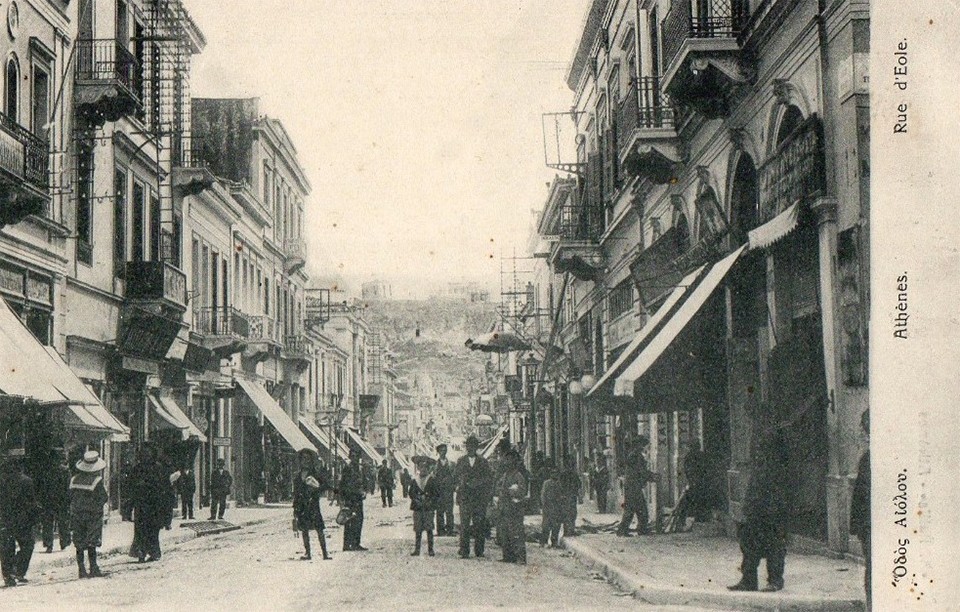 Καρτ ποστάλ της δεκαετίας 1900- 1910, στο βάθος διακρίνεται η ομπρέλα έξω από το κατάστημα Τσιμωνίδη. 
