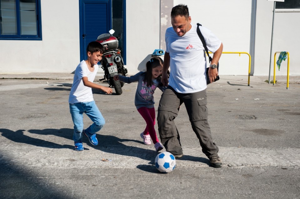 Σεπτέμβριος 2015: Ο χειρουργός των Γιατρών Χωρίς Σύνορα, Δημήτρης Γιαννούσης, παίζει ποδόσφαιρο με τα παιδιά των προσφύγων στο λιμάνι της Μυτιλήνης. «Τα παιδιά βιώνουν αυτό που συμβαίνει βουβά, γεγονός που εκδηλώνεται με ψυχοσωματικές ασθένειες». © Georgios Makkas/Panos Pictures