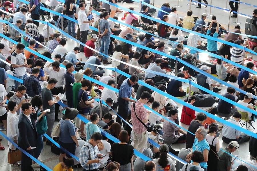  Άνθρωποι στήνονται στις ουρές για να αγοράσουν εισιτήρια για το Chuseok (τους μεγαλύτερους εορτασμούς τους ένεκεν του τέλους της σοδειάς) στον Σταθμό της Σεούλ στη Νότια Κορέα. YONHAP SOUTH KOREA OUT