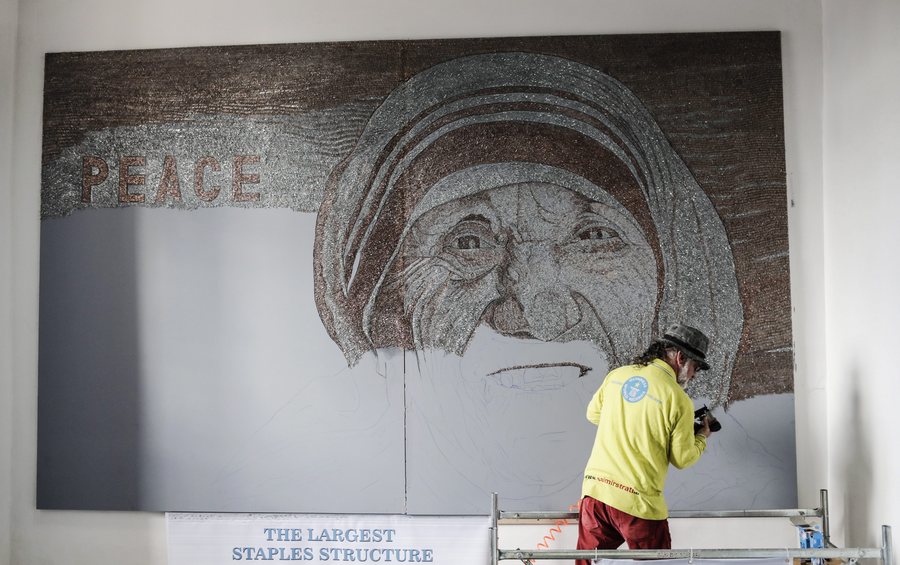 epa05635071 Guinness World Record holder Albanian artist Saimir Strati working on a mosaic of Saint Teresa in Pristina, Kosovo, 17 November 2016. Strati plans to complete the 10 square meter mosaic in 28 days using 1,500,000 staples. The mosaic will be placed inside the national museum of the Republic of Kosovo and is expected to become Strati's tenth world record and the world’s largest mosaic made from staples.  EPA/VALDRIN XHEMAJ