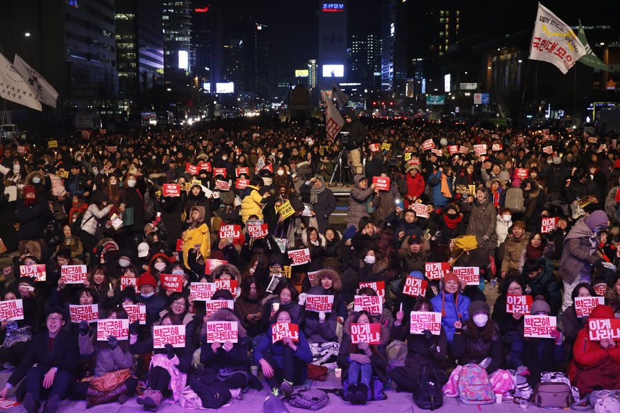 epa05647110 South Koreans shout slogans as they carry placards reading 'Park Geun-Hye Out' during a rally against South Korean President Park Geun-Hye on a main street in Seoul, South Korea, 25 November 2016. Protesters gathered to demand President Park's resignation after she has issued a rare public apology after acknowledging close ties to Choi Sun-sil, who is in the center of a corruption scandal.  EPA/JEON HEON-KYUN