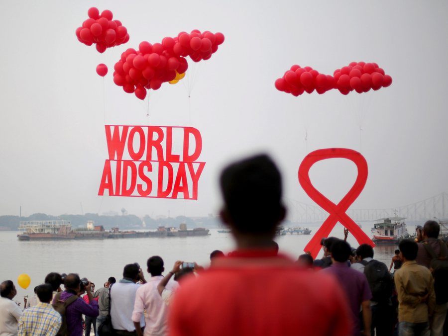 epa05653454 Activists hold the symolic 'Red Ribbon' as balloons are released during an AIDS awareness campaign on the eve of World AIDS Day near Howrah Bridge, on the bank of river Gangesin Calcutta, eastern India, 30 November 2016. World AIDS Day is observed every 01 December with calls from international health and advocacy organizations for the public to get involved in programs for awareness, prevention and treatment of HIV/AIDS.  EPA/PIYAL ADHIKARY