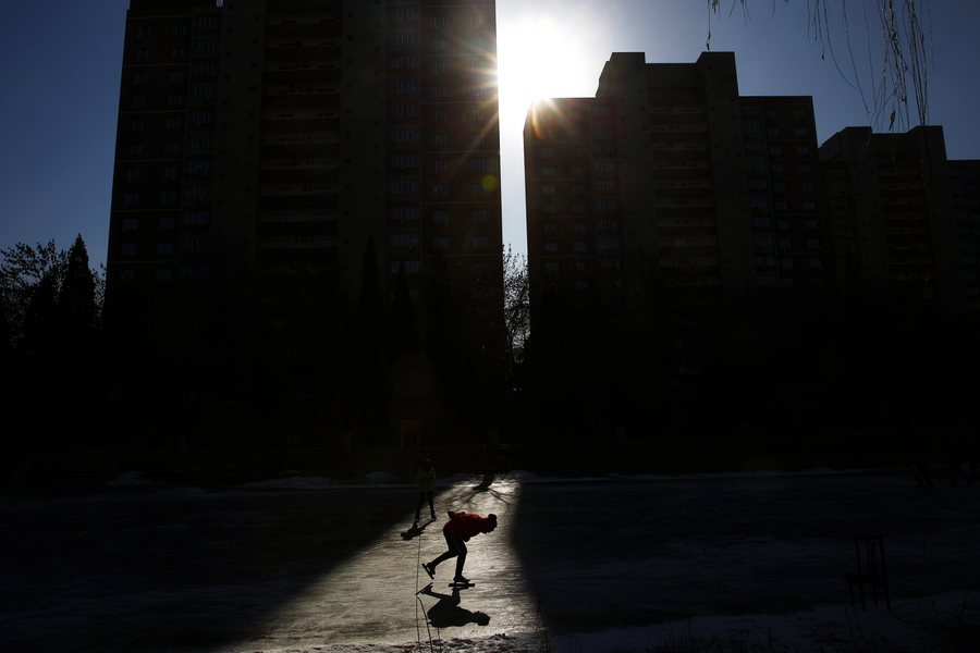 epaselect epa05689091 A Chinese man skates on a frozen river in Beijing City, China, 27 December 2016. Many Chinese people use their leisure time to skate and play ice hockey on this frozen lake during the winter season.  EPA/WU HONG