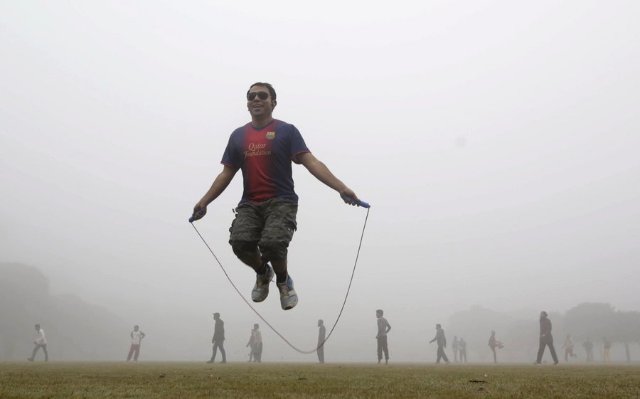 epa05691525 A man jumps in a jumping rope in a park covered with a heavy fog in Lahore, Pakistan, 30 December 2016. Many cities in Pakistan are experiencing unusual cold weather conditions as regular daytime temperatures fell to subzero degrees Celsius in wide parts of the country.  EPA/RAHAT DAR