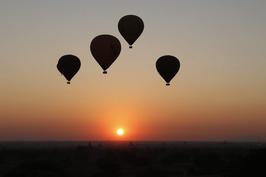 epaselect epa05748417 Balloons carrying visitors fly at sunrise over old temples of the ancient temple city of Bagan, Mandalay Region, Myanmar, 25 January 2017.  EPA/HEIN HTET