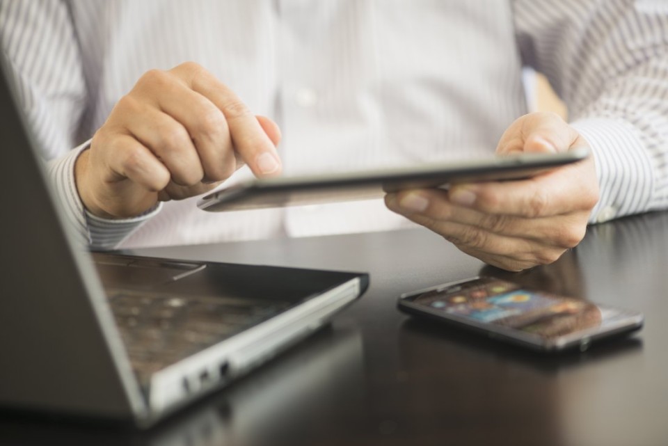 USA, New Jersey, Jersey City, Man using tablet pc, laptop and smartphone