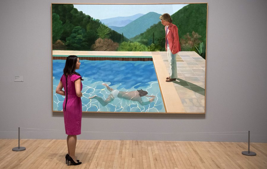 epa05774591 A member of gallery staff looks at a painting called "Portrait of an Artist (Pool with Two Figures)" British artist David Hockney during a press preview of a retrospective of his work at Tate Britain, Central London, Britain, 06 February 2017.  EPA/WILL OLIVER EDITORIAL USE ONLY  EDITORIAL USE ONLY