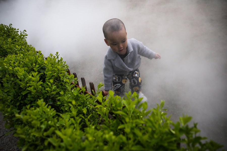 epa05879041 A child plays under a water spray at 798 Art District where the Mercedes-Benz China Fashion Week takes place, in Beijing, China, 30 March 2017. The Mercedes-Benz China Fashion Week runs from 24 March to 01 April.  EPA/ROMAN PILIPEY