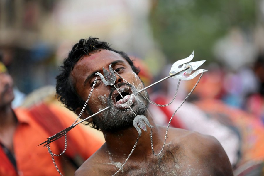 epa05890140 A Hindu devotee with iron rods piercing his cheek and toung as he takes part in a religious procession Vel Festival of the Hindu goddess Maha Mariamman (Sheetla Mata), in Hoogle village, North of Calcutta, eastern India, 05 April 2017. People get their bodies pierced with different kinds of metal needles and rods and participate in a religious procession as a thanks giving gesture to the goddess in return of their fulfilled wishes during the annual procession.  EPA/PIYAL ADHIKARY ATTENTION EDITORS: PICTURE CONTAINS GRAPHIC CONTENT
