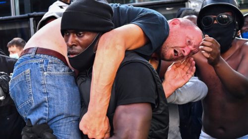 Η ιστορία της φωτογραφίας με τον μαύρο διαδηλωτή που κουβαλά έναν ακροδεξιό για να τον προστατεύσει