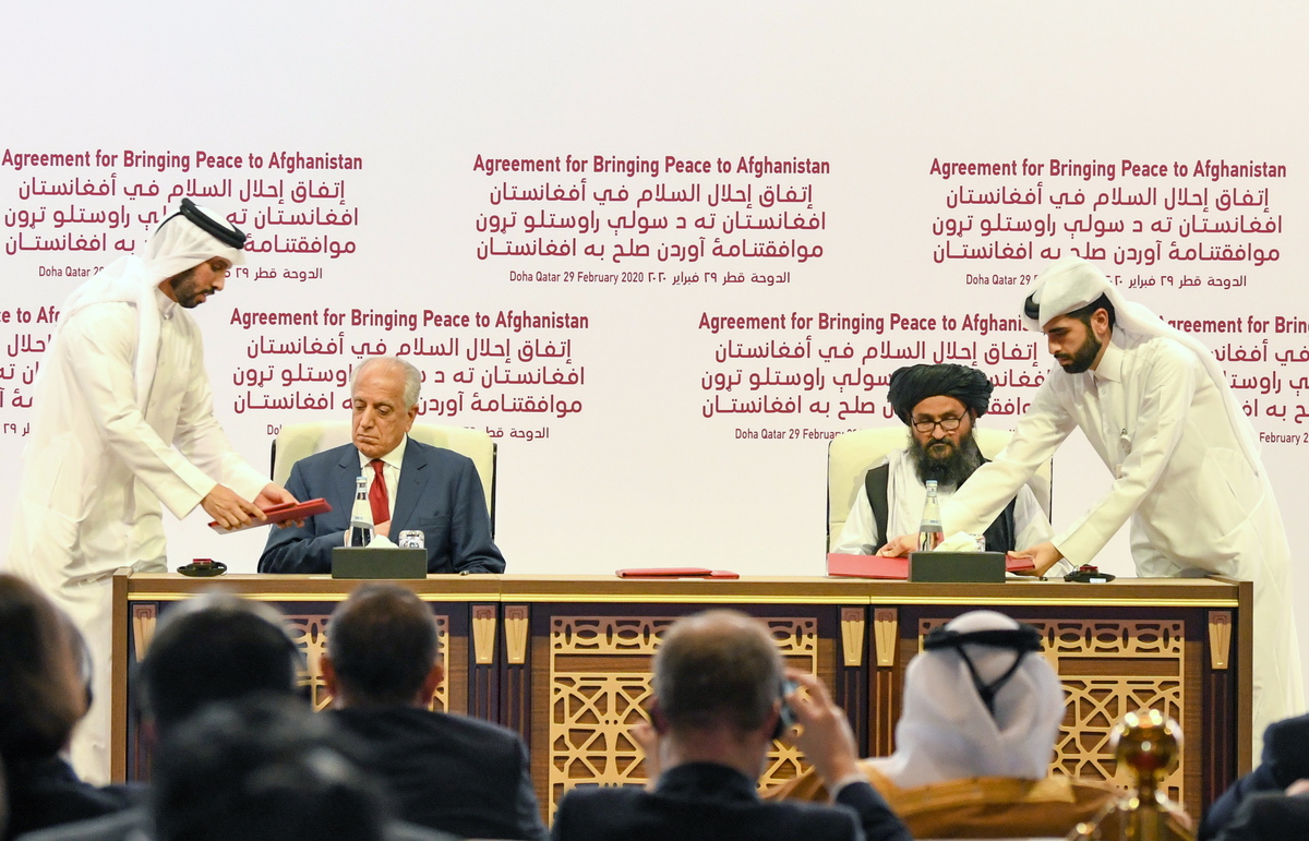 epaselect epa08259575 US Special Representative for Afghanistan Reconciliation Zalmay Khalilzad (2-L) and Taliban co-founder Mullah Abdul Ghani Baradar (2-R) sign the US-Taliban peace agreement during a ceremony in Doha, Qatar, 29 February 2020. The United States and the Taliban on 29 February penned a historic Agreement to Bringing Peace to Afghanistan which paves the way for the withdrawal of US troops and intra-Afghan negotiations. EPA/STRINGER