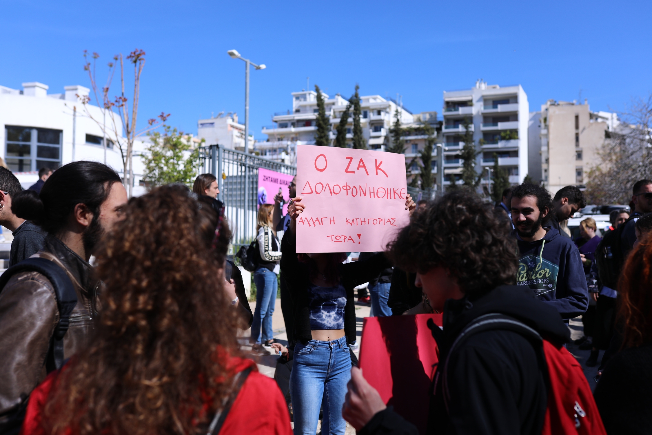 «Ο Ζακ δολοφονήθηκε. Αλλαγή κατηγορίας τώρα» γράφει το πλακάτ που κρατάει η κοπέλα στη συγκέντρωση αλληλεγγύης συλλογικοτήτων, έξω απο το πρωτοδικείο Αθηνών, κατά την έναρξη της δίκης για την δολοφονια του Ζακ Κωστόπουλου.