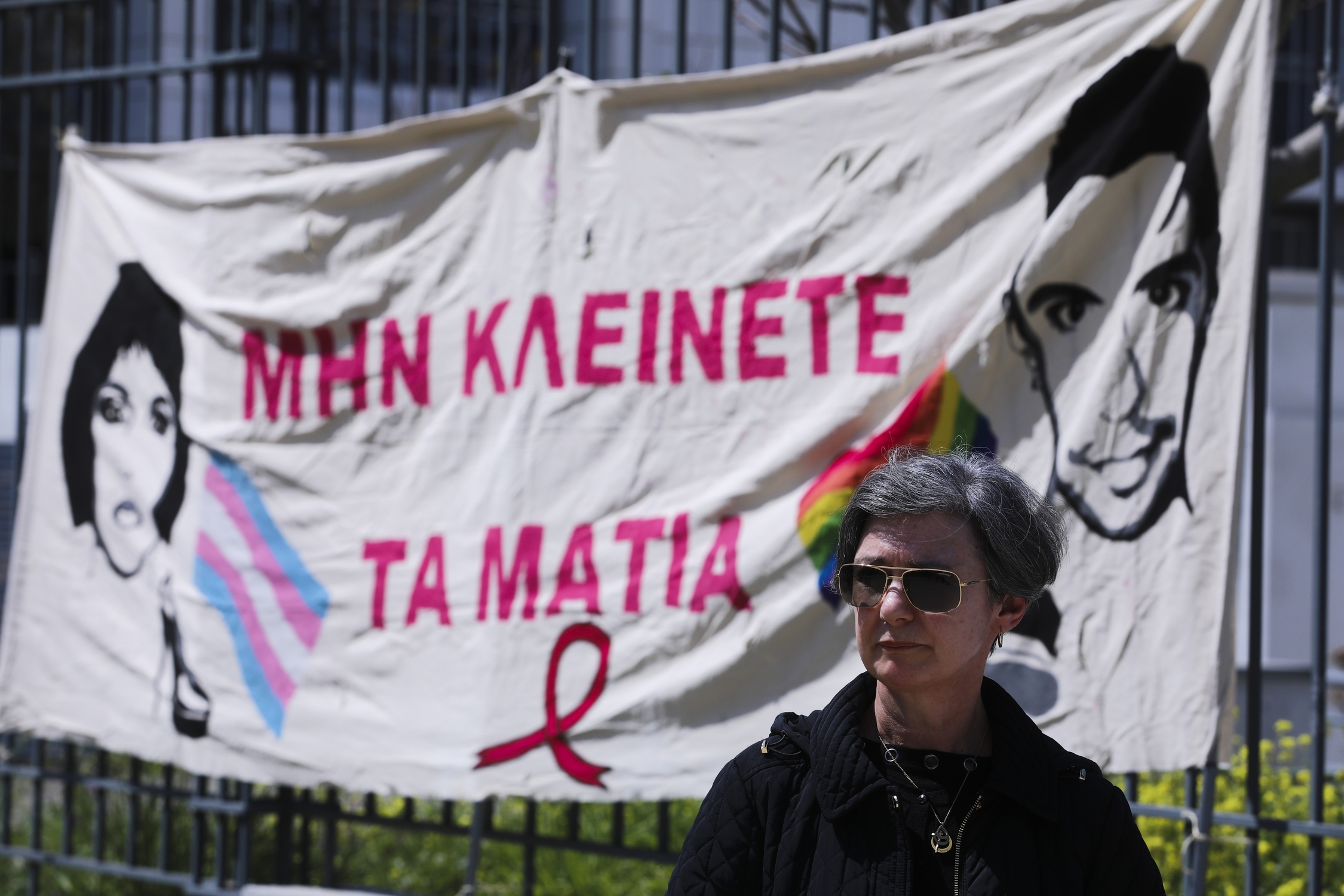 Η μητέρα του Ζακ Κωστόπουλου, Ελένη, μπροστά στο πανό «Μην κλείνετε τα μάτια», στη συγκέντρωση αλληλεγγύης συλλογικοτήτων, έξω απο το πρωτοδικείο Αθηνών, κατά την διάρκεια της δίκης για την δολοφονία της Zackie Oh.