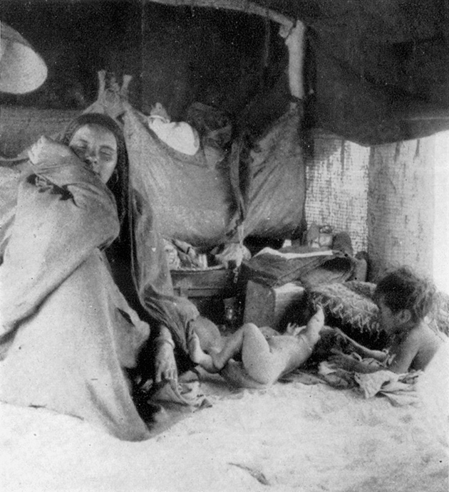 Το εσωτερικό μίας σκηνής. Οι τσάντες κρέμονται από τους ορθοστάτες. Τα παιδιά παίζουν στο έδαφος όπου στρώνεται μια παχυλή στρώση λεπτής άμμου.